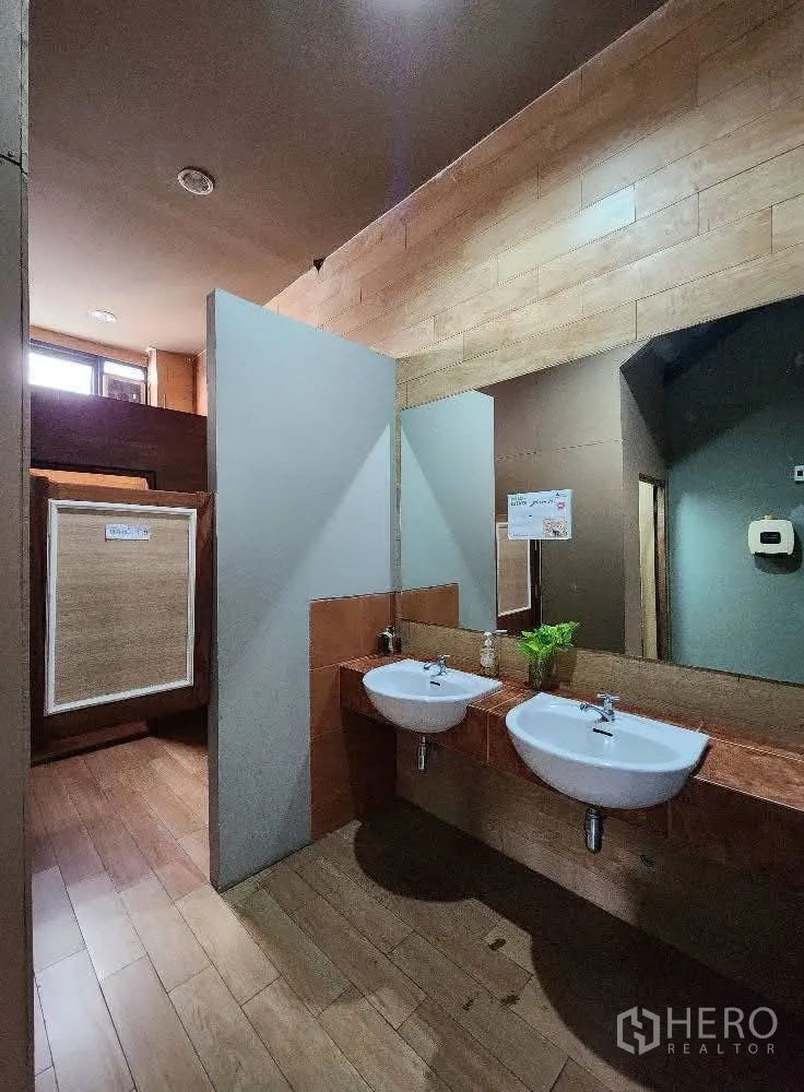 Home Office for rent in Mueang Nonthaburi, Nonthaburi - Washroom with twin basins, wood accents and stall partitions.