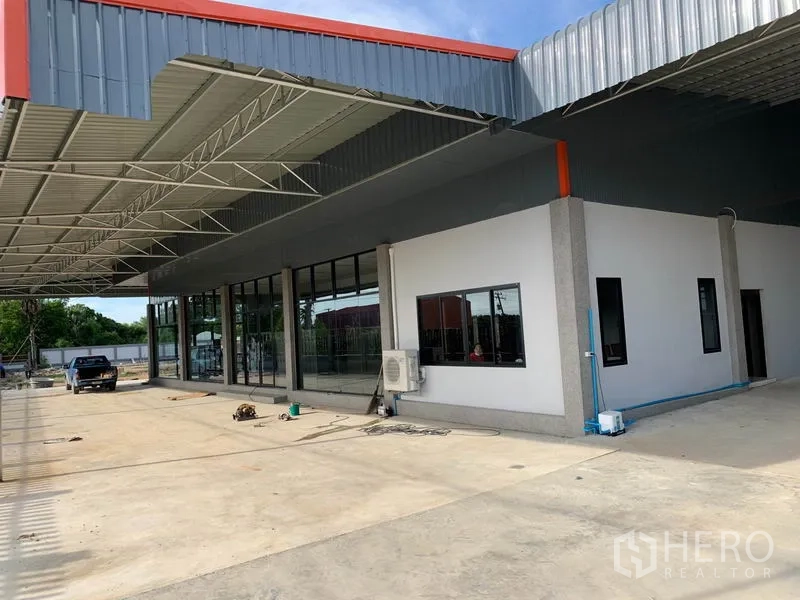 Warehouse for sale in Phra Nakhon Si Ayutthaya - Covered loading area with glass-fronted office and a white administrative block.