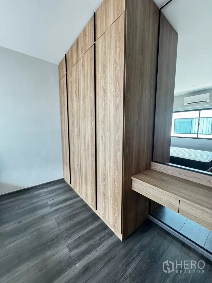 Townhouse for rent in Bang Phli, Samut Prakan - Built-in wardrobe wall with dressing table and mirror in wood finish.