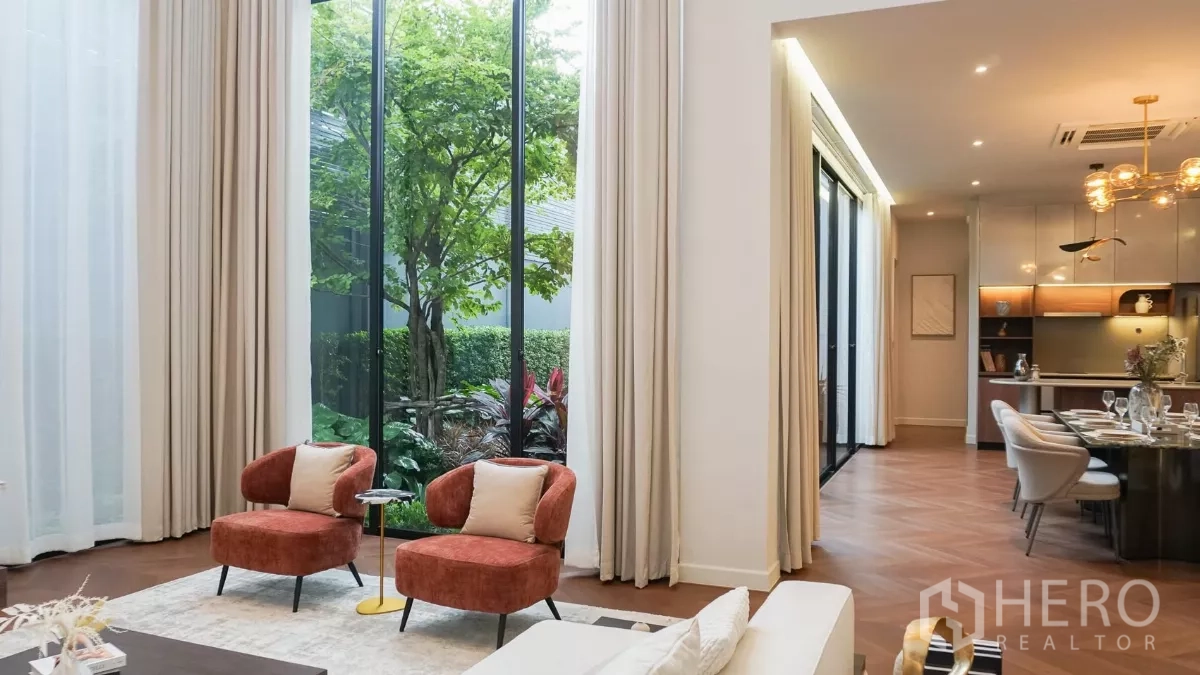独立式住宅 出租或出售在Bang Kapi, Bangkok - 落地玻璃旁的舒适休闲座位，可观庭院绿意。