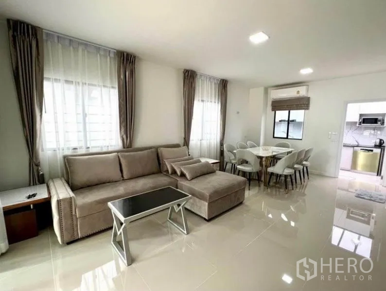 ทาวน์เฮาส์ ให้เช่าในWang Thonglang, Bangkok - พื้นที่นั่งเล่นพร้อมโซฟาเข้ามุม ชุดโต๊ะอาหาร และทางเชื่อมไปครัวแยก