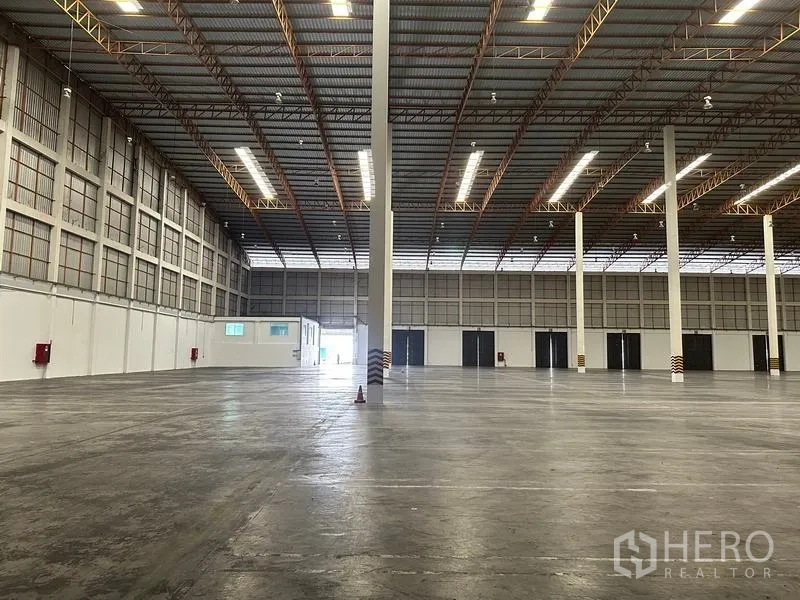 คลังสินค้า ให้เช่าในPhra Nakhon Si Ayutthaya - ฮอลล์เก็บสินค้าโล่งกว้าง มีประตูโรลเลอร์หลายบานและโครงหลังคาเหล็ก