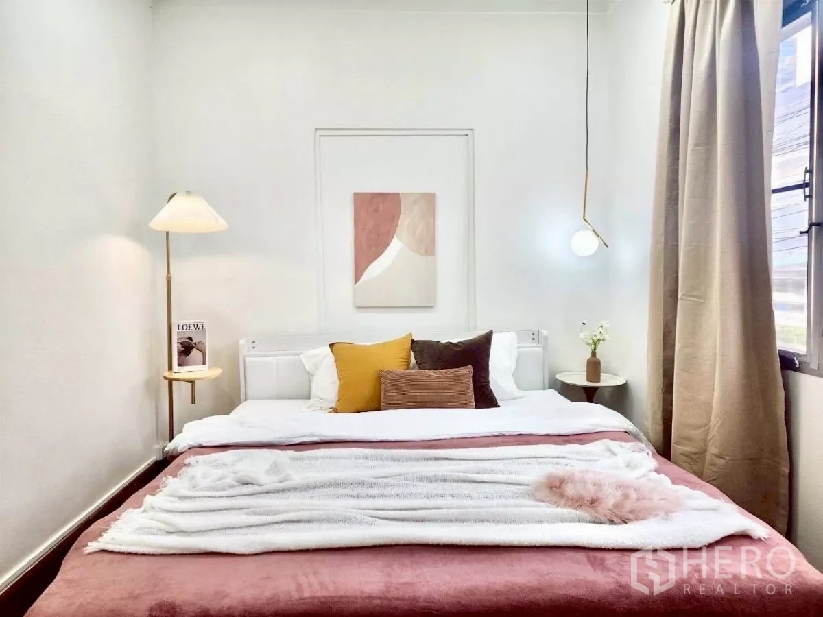Detached House for rent in Chatuchak, Bangkok - Minimalist bedroom with pendant lights, artwork and floor-length curtains.