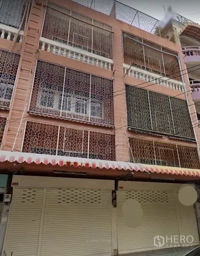 อาคารพาณิชย์ ให้เช่าในHuai Khwang, Bangkok - ด้านหน้าอาคารพาณิชย์หลายชั้นในห้วยขวาง พร้อมเหล็กดัด ประตูม้วน และกันสาดลายทาง