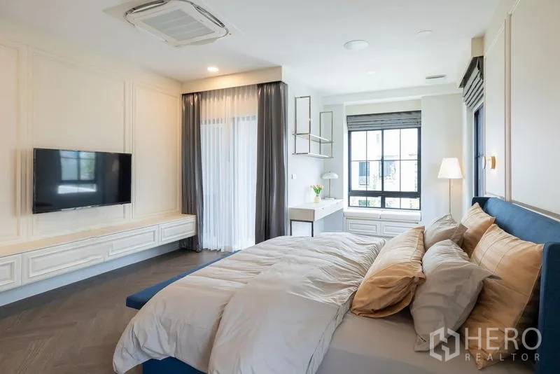 Detached House for sale in Saphan Sung, Bangkok - Primary bedroom with TV wall, large windows and private balcony door.