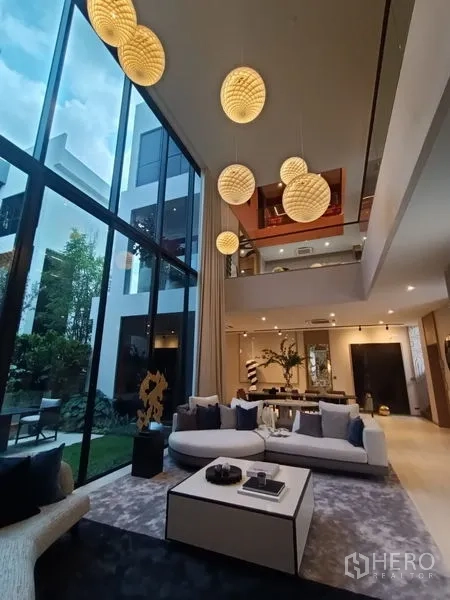 บ้าน ขาย - พื้นที่นั่งเล่นโอ่โถง เพดานสูง โคมไฟระย้า และวิวสวน