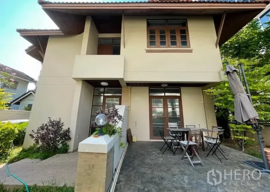 Detached House for rent in Khlong Toei, Bangkok - Two-storey detached house exterior with covered patio, outdoor dining set and green hedges.