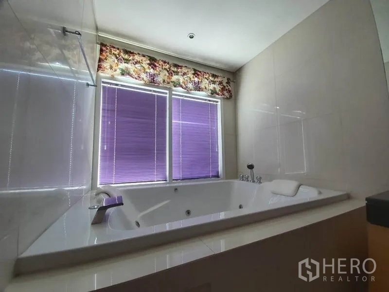 คอนโด ขายในWatthana, Bangkok - ห้องน้ำสมัยใหม่พร้อมอ่างจากุซซี่สีขาว ใต้หน้าต่างบานใหญ่ม่วง