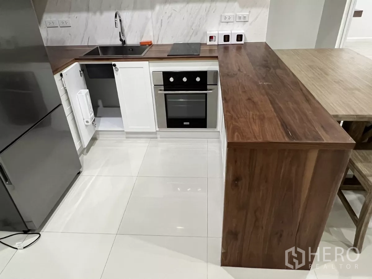 คอนโด ให้เช่าในBang Kapi, Bangkok - ครัวรูปตัวแอล เคาน์เตอร์ไม้ เตาอบและอ่างล้างจาน