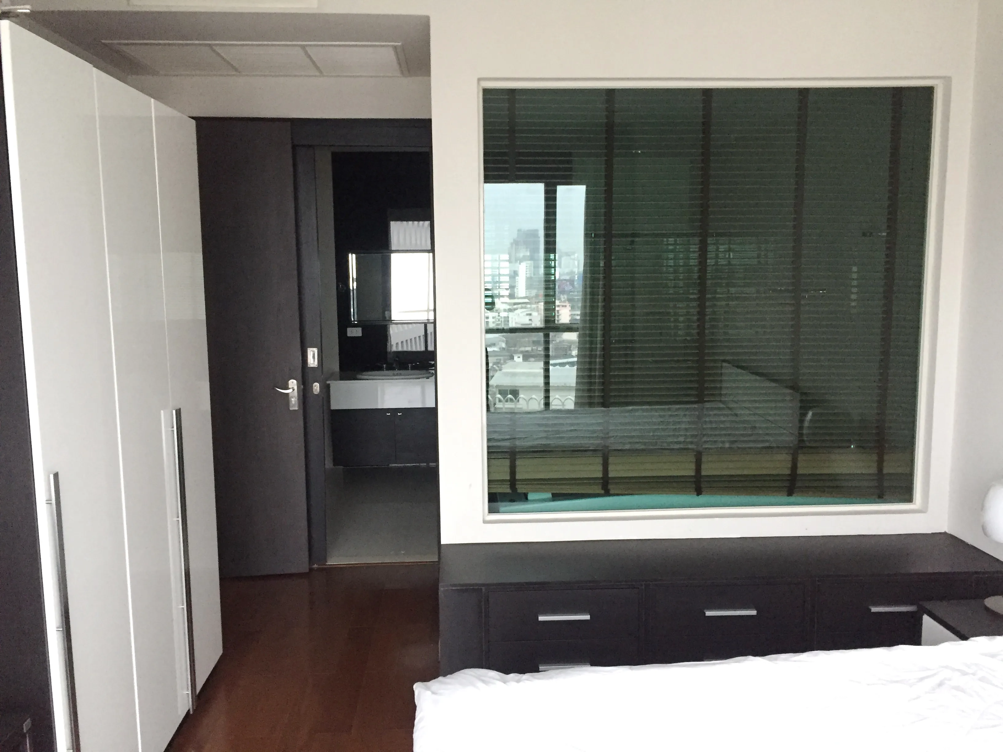 คอนโด ให้เช่าหรือขายในPathum Wan, Bangkok - ห้องนอนพร้อมตู้เสื้อผ้าบานเงา ฉากกั้นกระจกพร้อมมู่ลี่ มองเห็นวิวเมืองเล็กน้อย