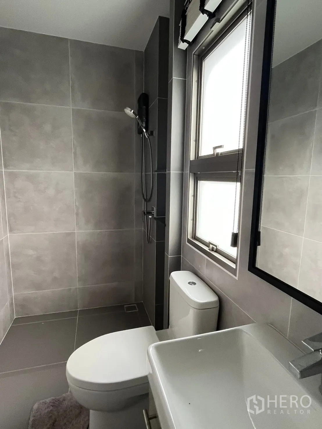 独栋房屋 for rent or sale in Bueng Kum, Bangkok - 现代灰色瓷砖卫浴，带淋浴、窗户、坐便与台盆。