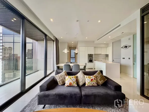 คอนโด ให้เช่าในWatthana, Bangkok - ห้องนั่งเล่นและรับประทานอาหาร มีผนังกระจกสูงจรดเพดาน มองเห็นวิวสกายไลน์ ใกล้ครัวเปิด