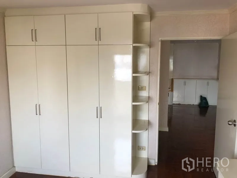 คอนโด ขายในWatthana, Bangkok - ตู้เสื้อผ้าบิลท์อินในห้องนอนพร้อมชั้นวาง มองเห็นไปยังพื้นที่นั่งเล่น