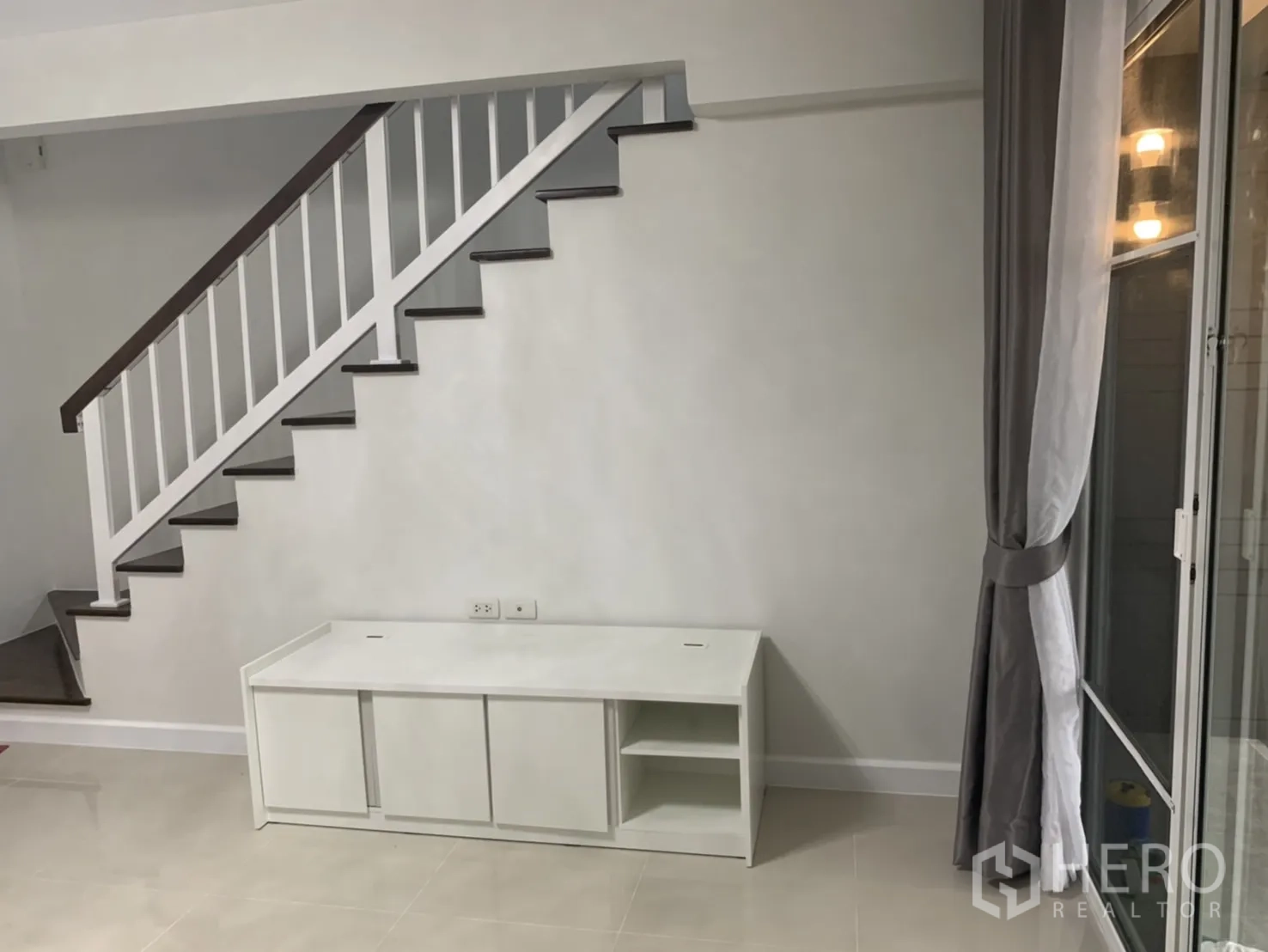 联排别墅 for rent in Bang Kapi, Bangkok - 白色栏杆楼梯与楼梯下的矮电视柜。
