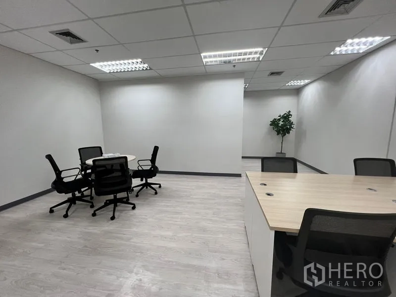 Office Space for rent in Sathon, Bangkok - Spacious open office with round meeting table, desks and a decorative potted plant.