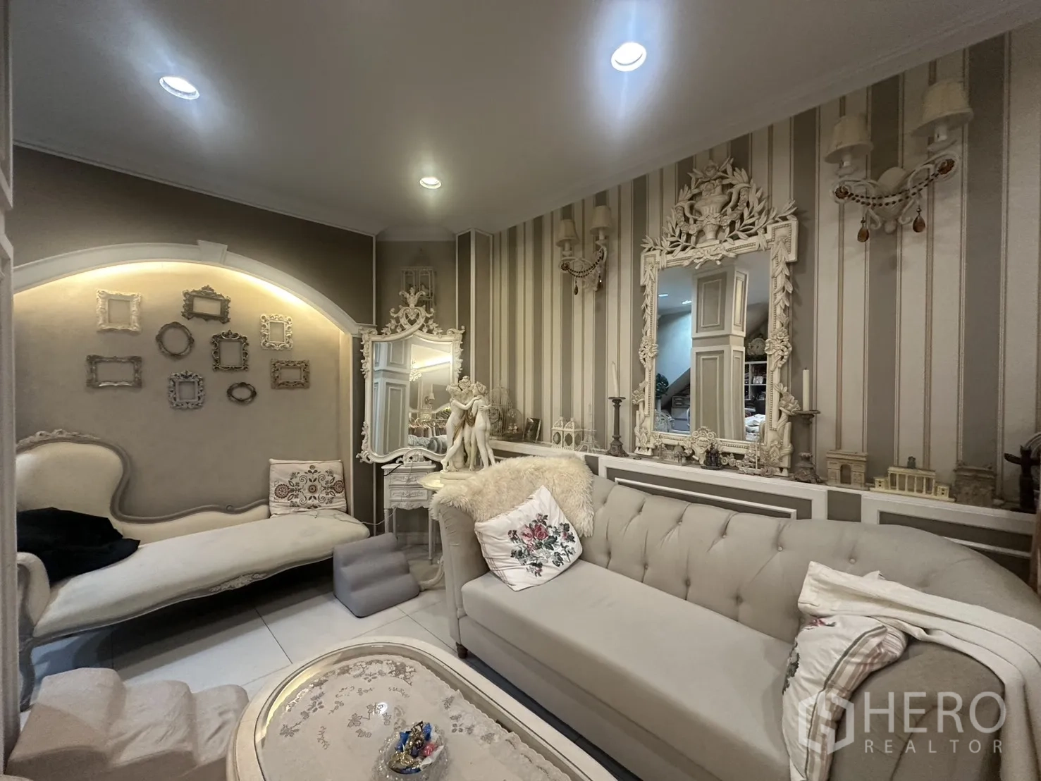 Shophouse for sale in Watthana, Bangkok - Ornate living room with tufted sofa, decorative mirrors and accent lighting.