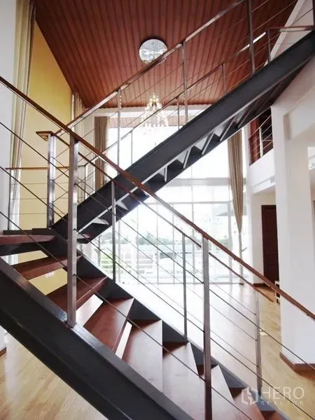 公寓 出租在Chatuchak, Bangkok - 现代钢木楼梯，置于挑高空间与大面积采光窗前。