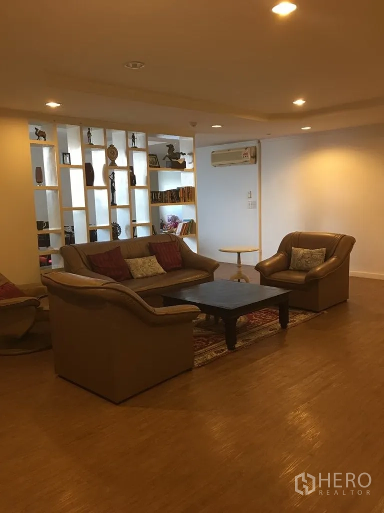 公寓 for rent in Watthana, Bangkok - 客厅有皮质沙发组合、茶几与展示架。
