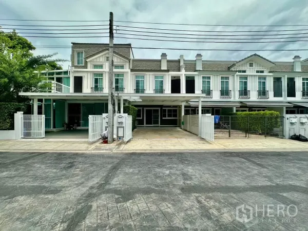 联排别墅 出租在Prawet, Bangkok - 北欧风联排外立面，白色墙面与小阳台的街景。