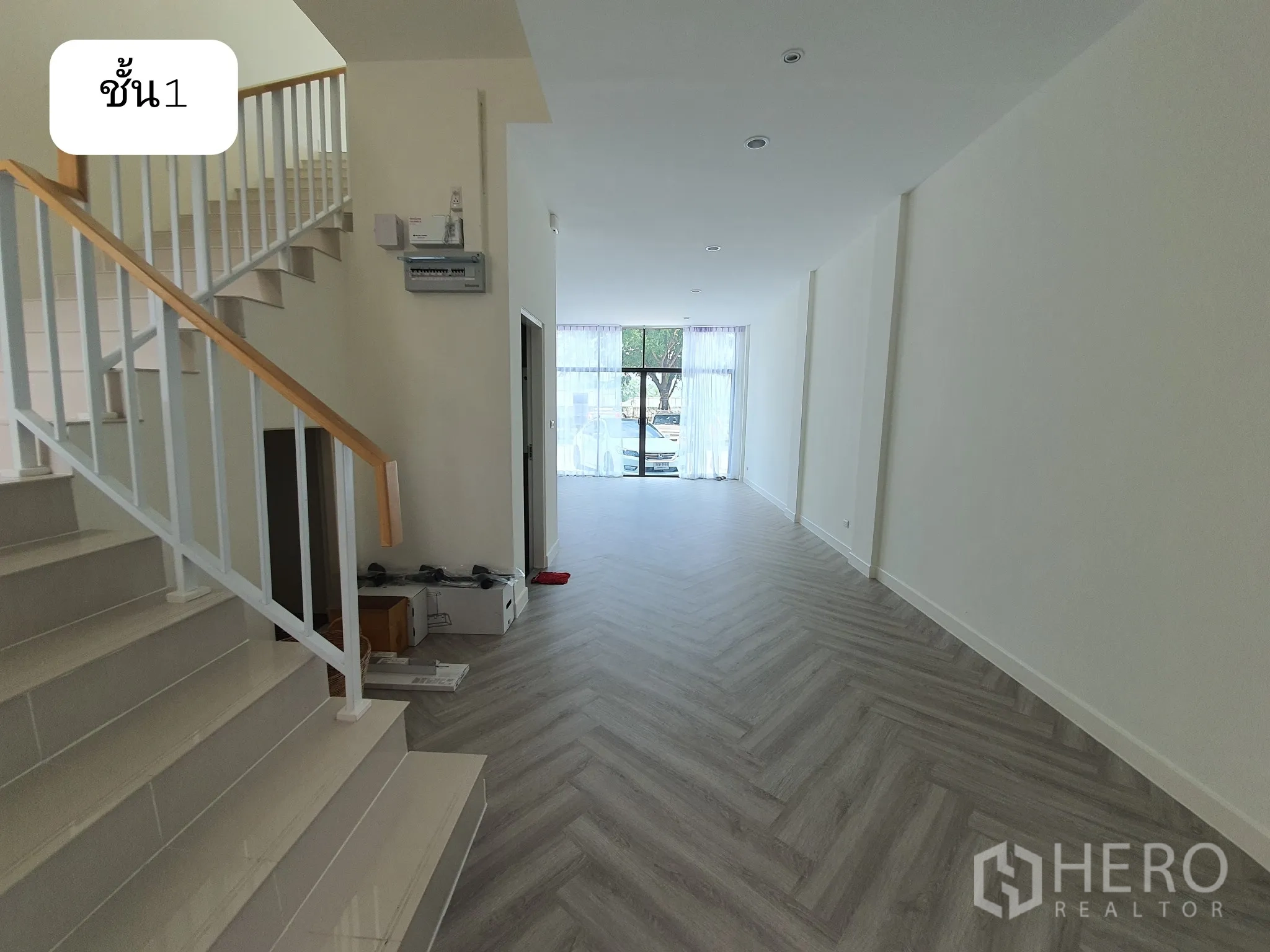 Home Office for rent or sale in Prawet, Bangkok - Ground floor corridor with staircase and long herringbone-floored space leading to the frontage.