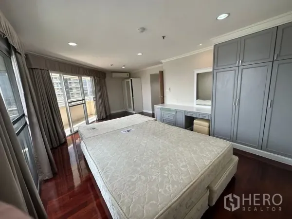 คอนโด ให้เช่าในWatthana, Bangkok - ห้องนอนมาสเตอร์กว้าง พื้นไม้ ตู้เสื้อผ้าบิวท์อิน โต๊ะเครื่องแป้ง และระเบียงชมวิวเมือง