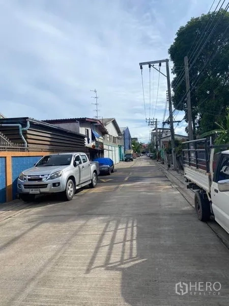 工厂 出售在Bang Khun Thian, Bangkok - 工厂前道路另一视角，停放的皮卡和电线杆