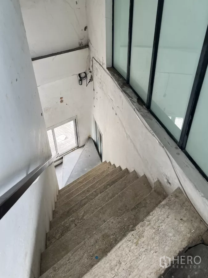 พื้นที่ขายปลีก ให้เช่า - บันไดภายในขั้นคอนกรีตและช่องแสงกระจกฝ้าเชื่อมสู่ทางเข้า