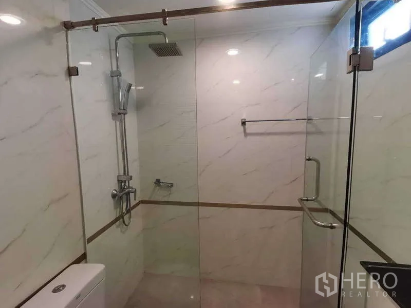 อพาร์ทเมนท์ ให้เช่า - ภาพระยะใกล้ตู้ฝักบัวกระจกพร้อมเรนชาวเวอร์และฝักบัวมือถือ