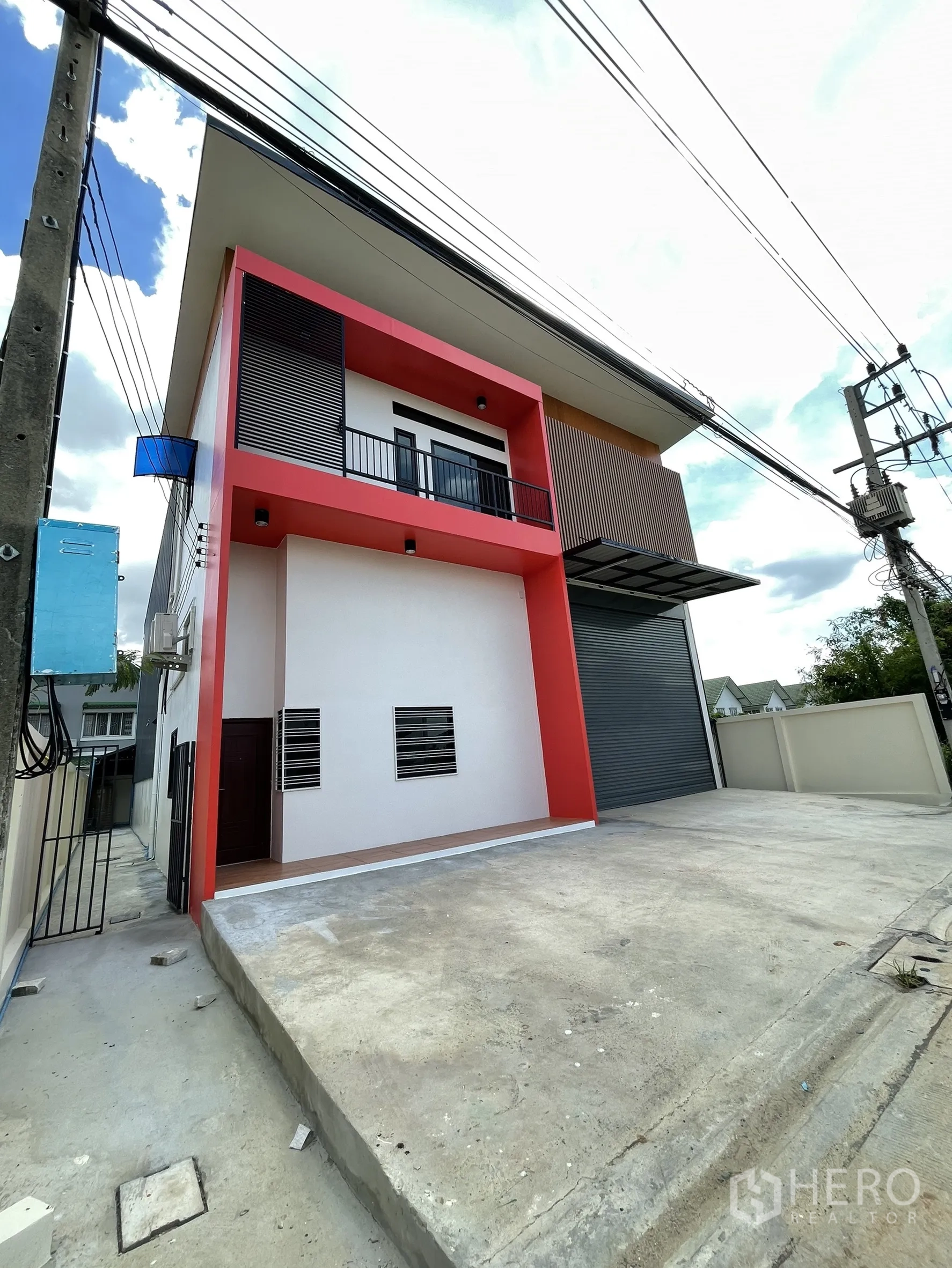 โรงงาน ให้เช่าหรือขายในLam Luk Ka, Pathum Thani - มุมมองเฉียงของด้านหน้า มีลานคอนกรีตกว้างและระเบียงเหนือออฟฟิศ