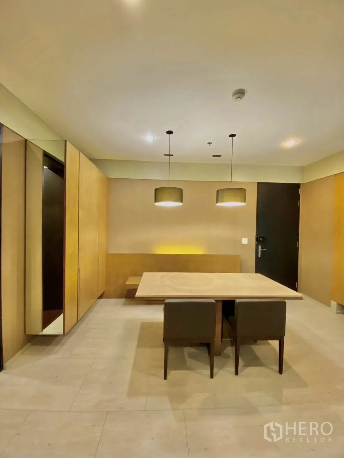 公寓 for rent in Khlong Toei, Bangkok - 入户旁餐区，灯光温暖，配两把椅子。