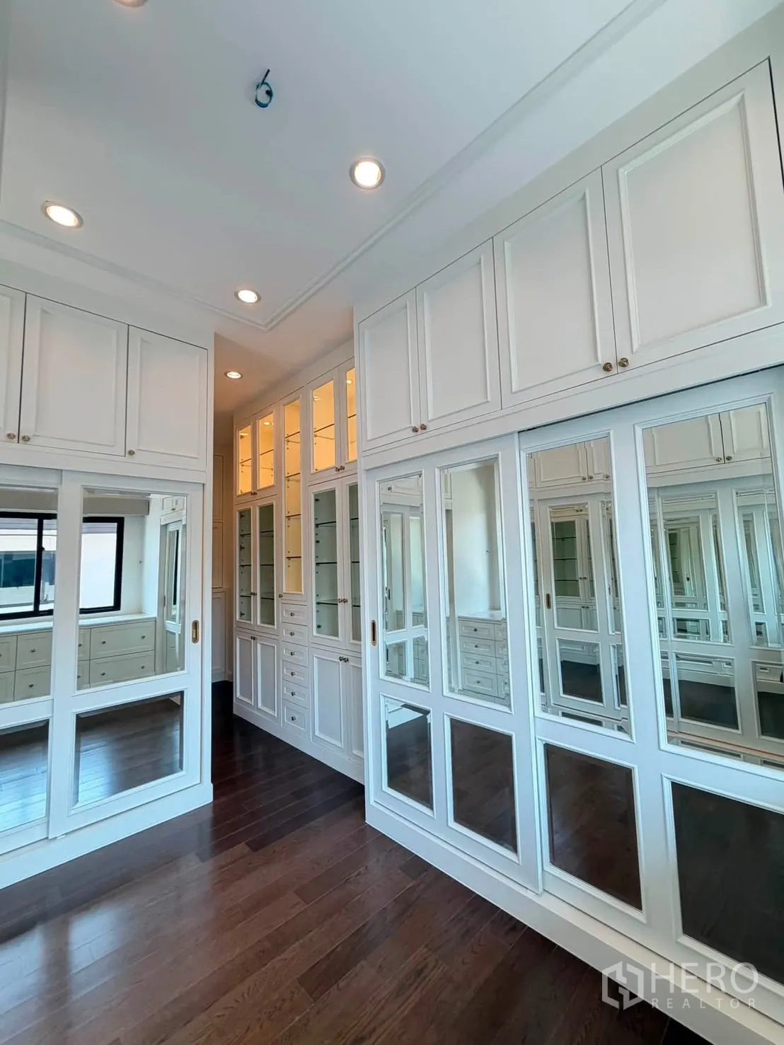 Detached House for rent or sale in Prawet, Bangkok - Walk-in closet with mirrored wardrobes and ample cabinetry.