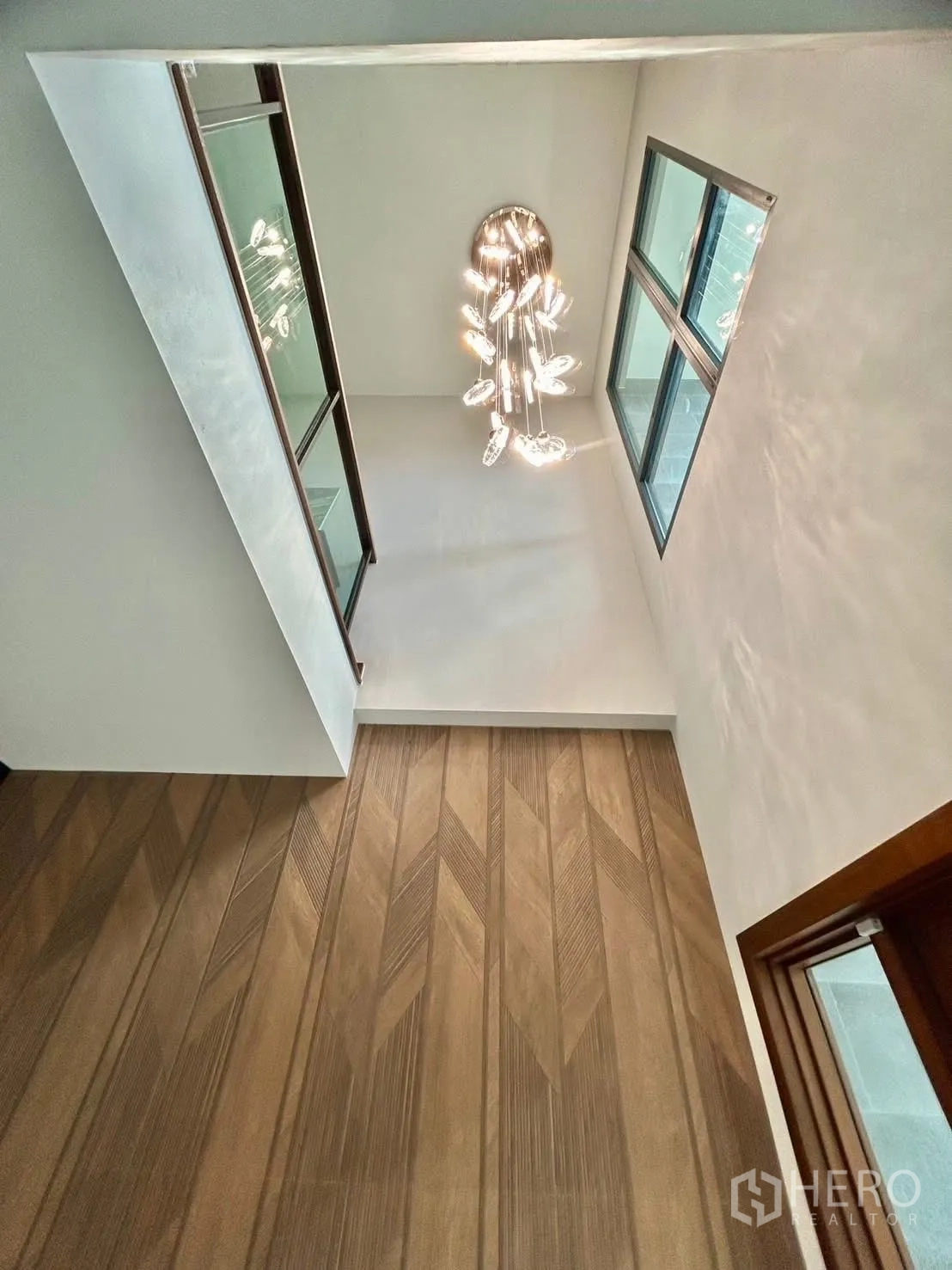 独栋房屋 for rent in Bang Phli, Samut Prakan - 双层挑高楼梯间，水晶吊灯与玻璃扶手。