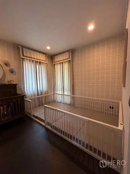 独立式住宅 出租在Bang Kapi, Bangkok - 温馨儿童房，转角窗、浅色墙纸与游戏围栏区。