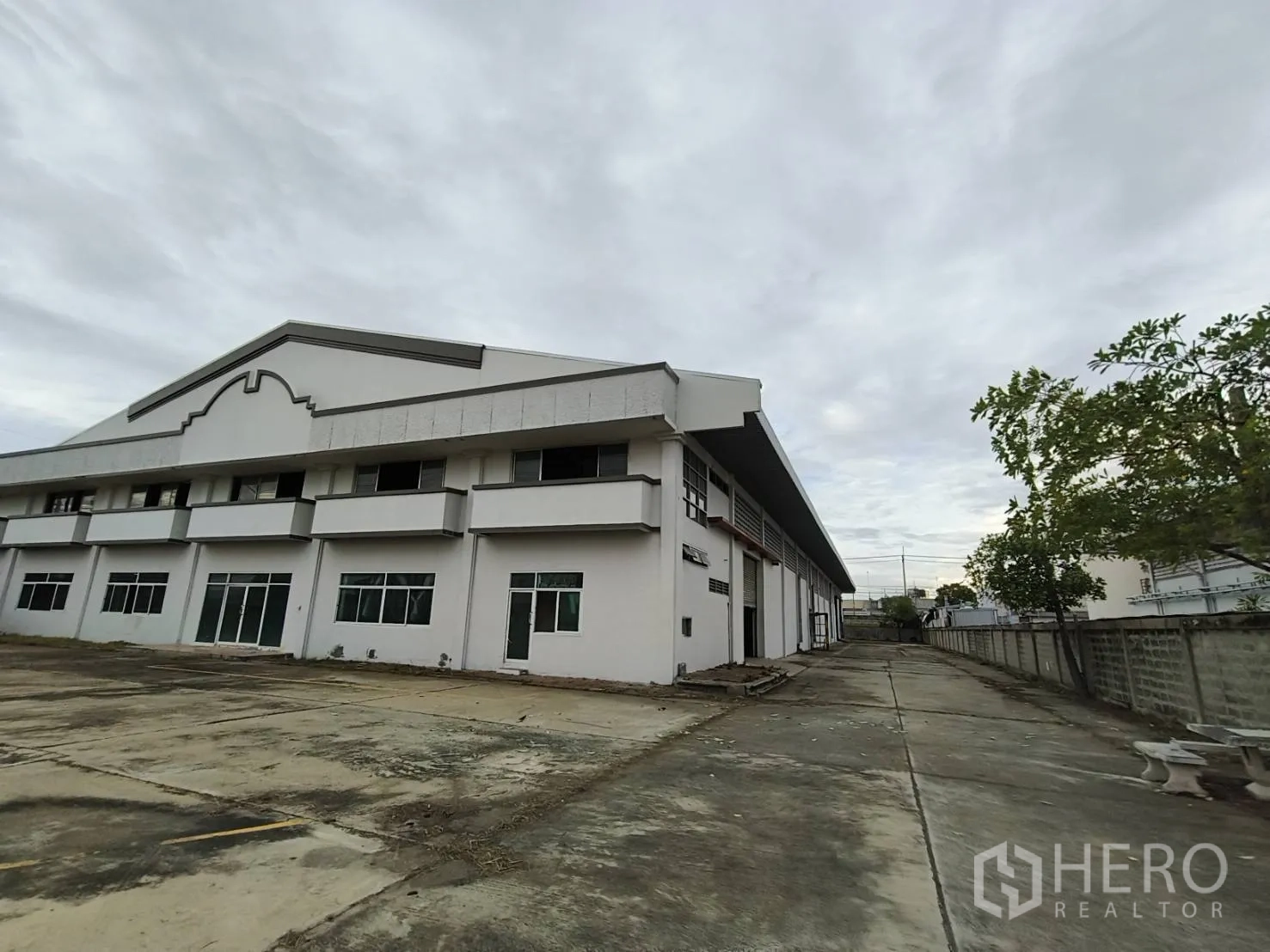 仓库 for rent in Phra Nakhon Si Ayutthaya, Phra Nakhon Si Ayutthaya - 仓库侧立面，硬质场地、窗户以及沿墙的车行通道。