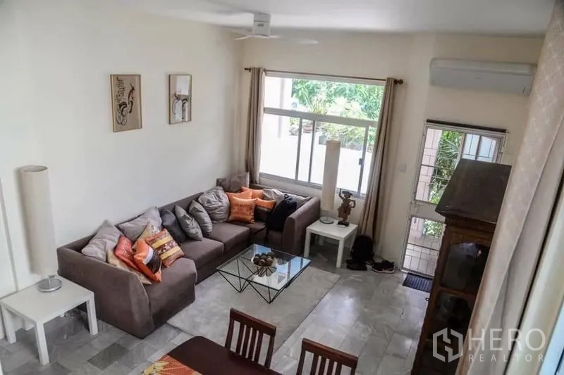 สำนักงานที่บ้าน ให้เช่าในMin Buri, Bangkok - ห้องนั่งเล่นชั้นล่างโปร่งสว่าง หน้าต่างบานใหญ่ โซฟาเข้ามุมและชุดทานอาหารมองสวน