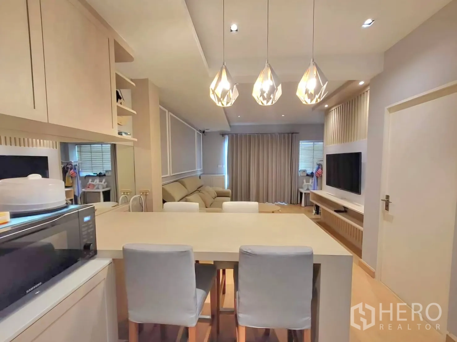 Townhouse for rent in Bang Phli, Samut Prakan - Dining island with pendant lights and cabinetry overlooking the living area.