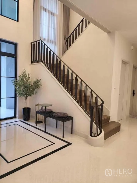บ้าน ให้เช่าในSaphan Sung, Bangkok - บันไดราวสีเข้มในโถงโปร่งแสงสูง