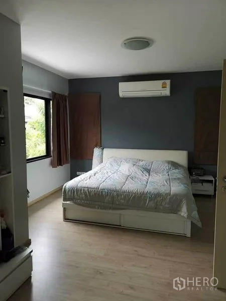 Detached House for sale in Bang Phli, Samut Prakan - Master bedroom with gray feature wall, large window and wall-mounted air conditioner