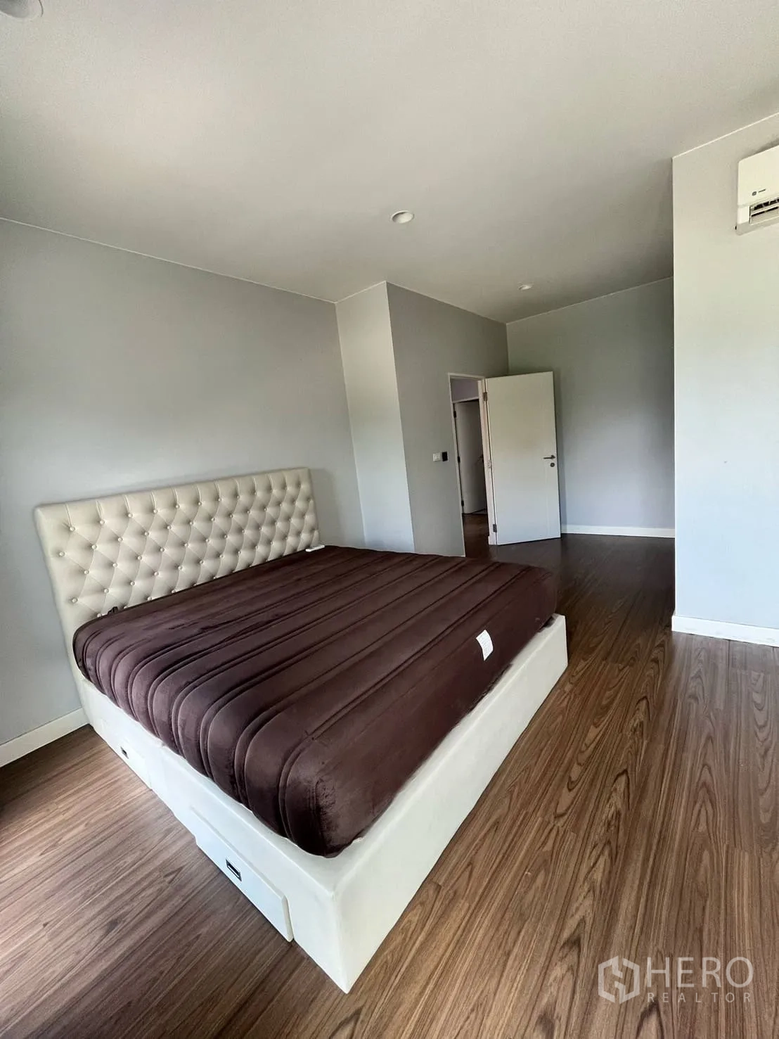 บ้าน ให้เช่าหรือขายในLam Luk Ka, Pathum Thani - ห้องนอนใหญ่ หัวเตียงบุหนัง พื้นไม้ และโทนสีเรียบ