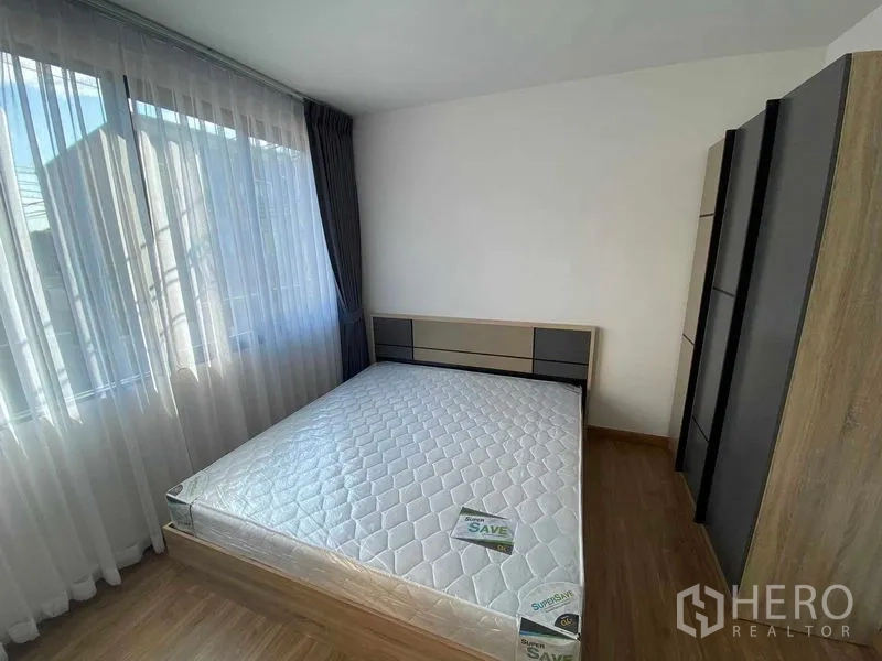 联排别墅 出租在Prawet, Bangkok - 主卧配大窗与纱帘，带内置衣柜。