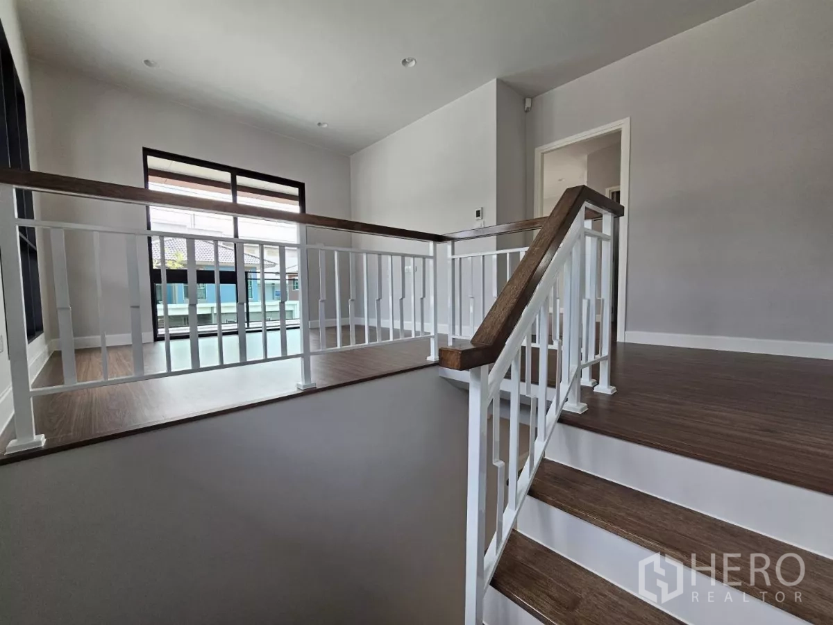 บ้าน ขายในLam Luk Ka, Pathum Thani - โถงบันไดชั้นสอง ราวบันไดสีขาวและประตูออกสู่ระเบียง