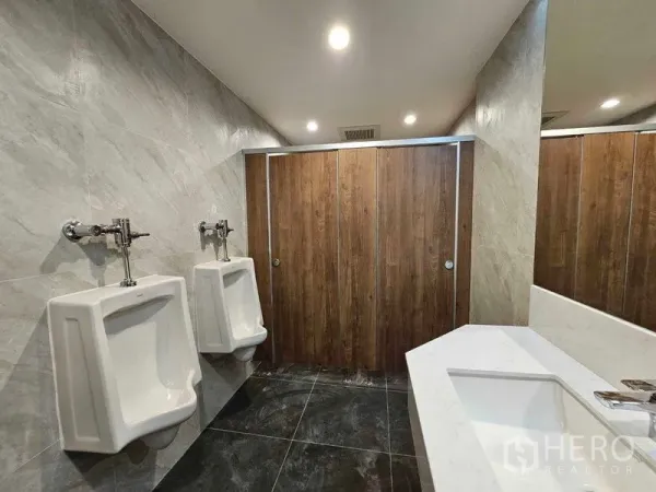 办公空间 出租在Bang Rak, Bangkok - 男卫间设有小便器、隔间与长台面洗手池。