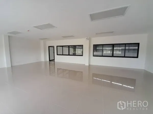 工厂 出租在Mueang Rayong, Rayong - 明亮的室内办公区，瓷砖地面与黑框窗户。