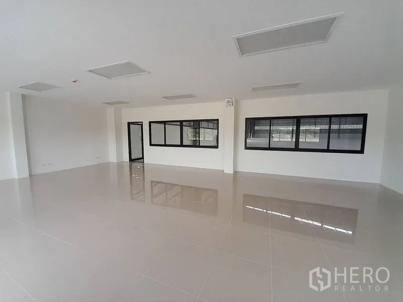 工厂 出租在Mueang Rayong, Rayong - 明亮的室内办公区，瓷砖地面与黑框窗户。