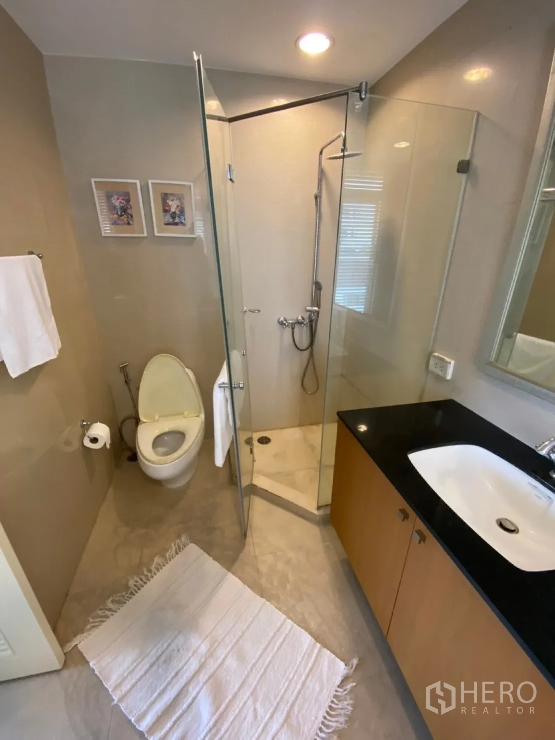 Condominium for rent in Watthana, Bangkok - Bathroom featuring glass-enclosed shower, vanity and toilet.