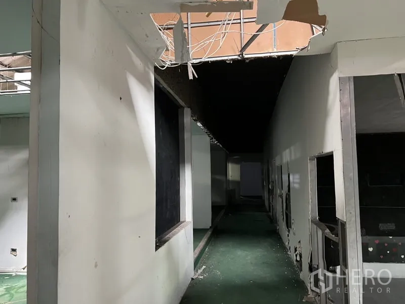 货栈 出租在Bang Kapi, Bangkok - 服务走廊电缆外露与墙体开口，通往多间仓库房间。