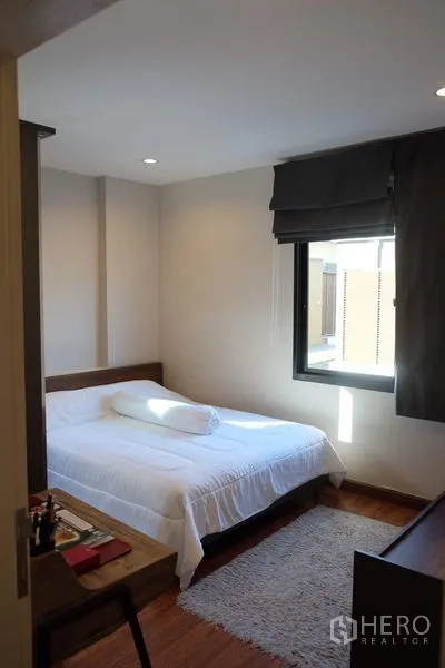 Detached House for rent in Bang Phli, Samut Prakan - Cozy bedroom with a window, white bedding and wood floors.