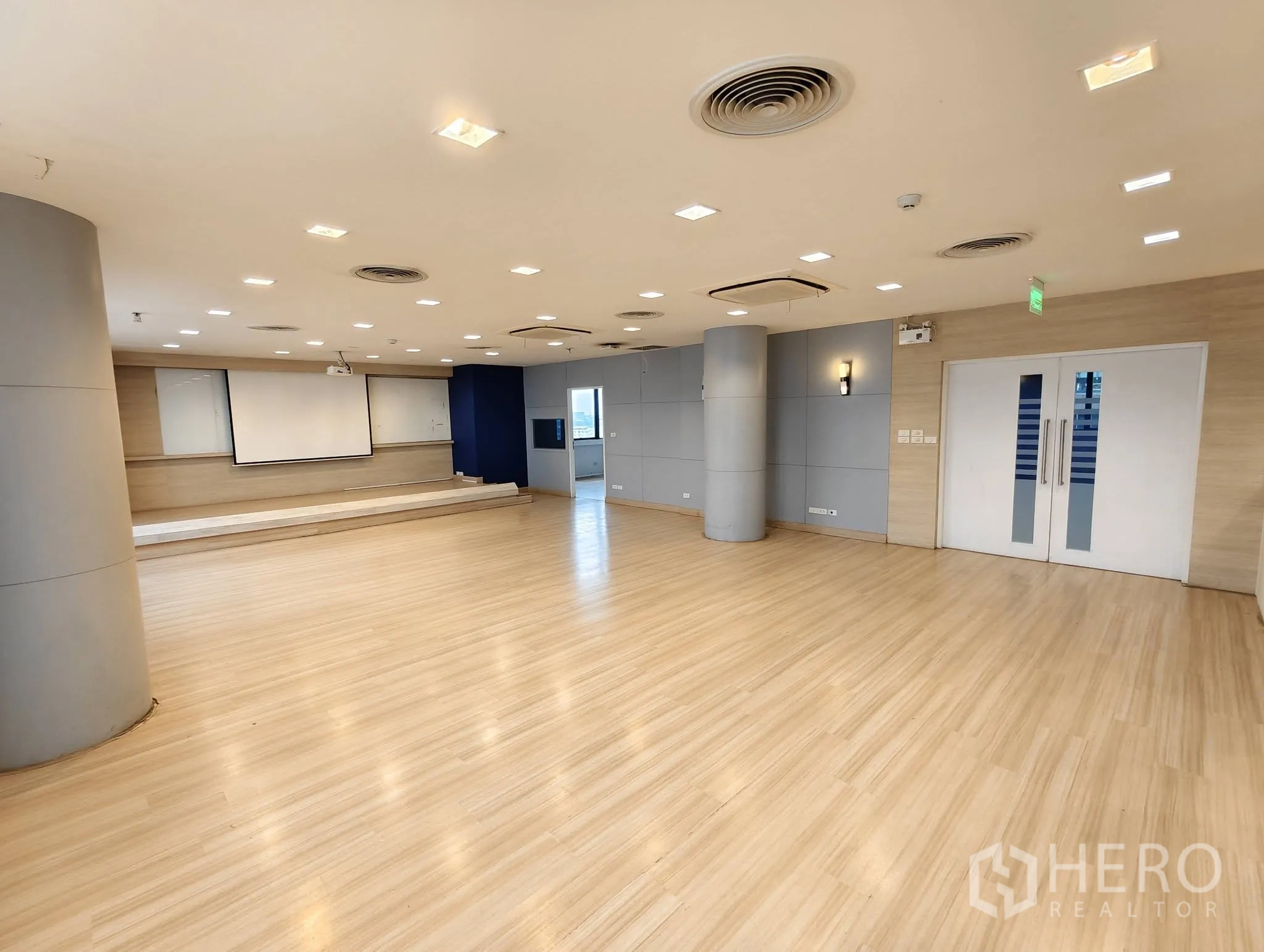 Office Space for rent in Lak Si, Bangkok - Spacious hall with projector screen, double doors, and long windows.