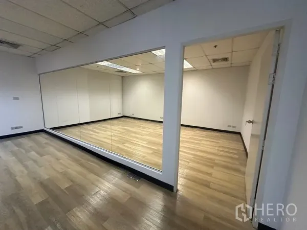 办公空间 出租在Phra Khanong, Bangkok - 玻璃隔断会议室，配大镜面与单开门，地面为木纹地板。