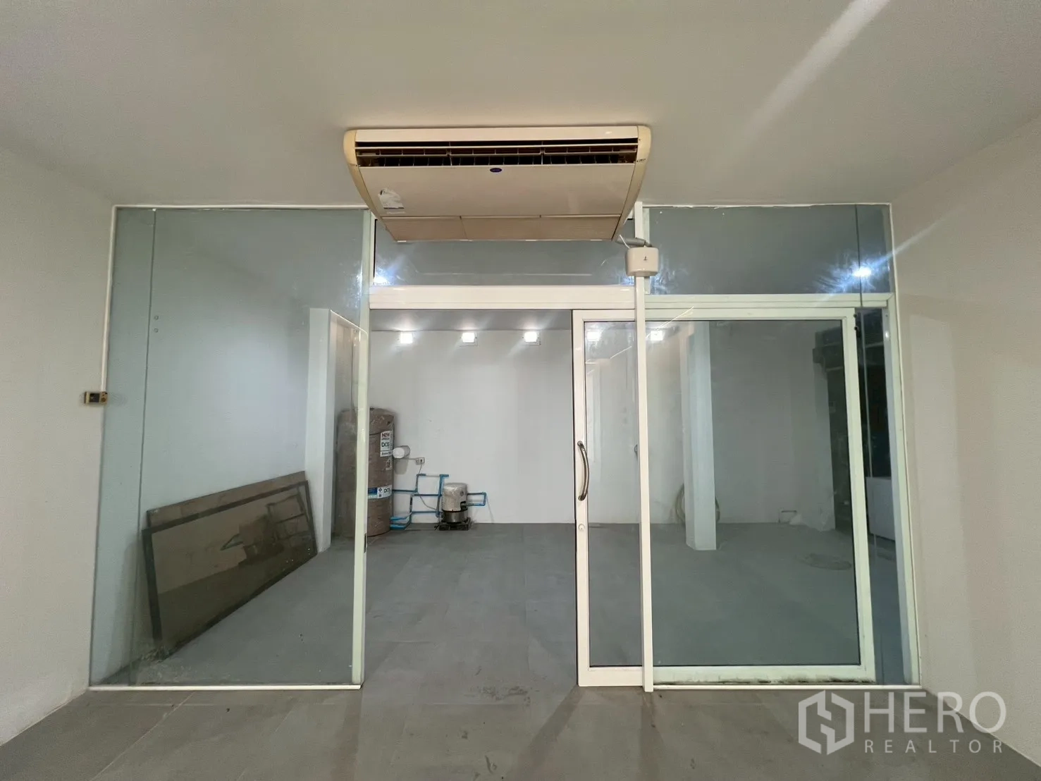 Home Office for rent in Watthana, Bangkok - Glass-enclosed office or meeting room with an air-conditioning unit above.